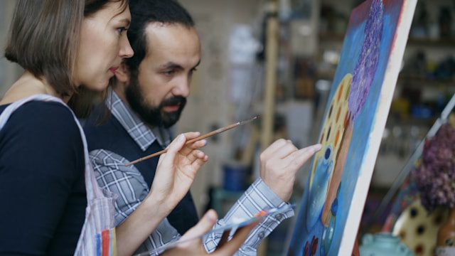 Gros plan sur un Art Dealer ou un expert en art examinant attentivement une peinture, peut-être avec une loupe, pour vérifier son authenticité, sa signature, ou les matériaux utilisés.